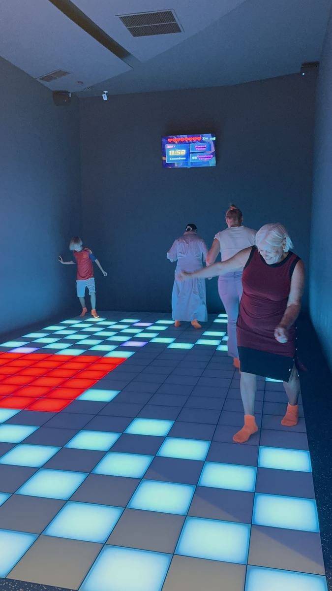 Adulți și copii jucând același joc pe podeaua LED la Hai Pixel, Chișinău