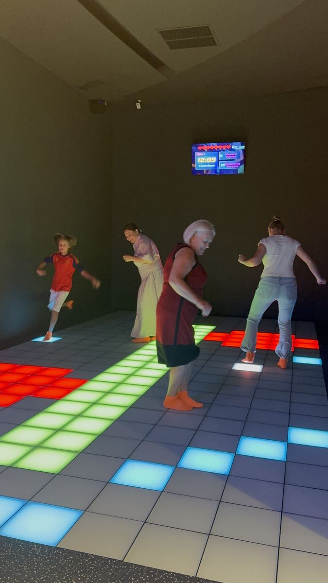 Grup de adulți de vârste diferite alergând pe podeaua LED aprinsă la Hai Pixel Chișinău