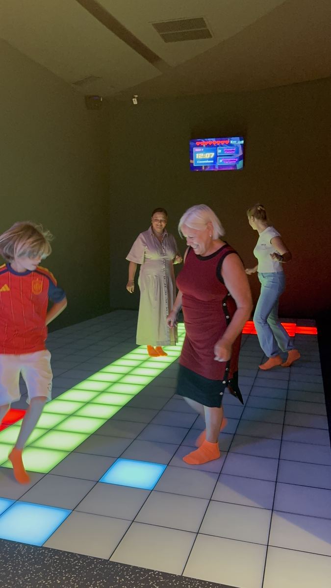Grup de adulți răspândiți pe podeaua LED în timpul unei runde active la Hai Pixel, Chișinău
