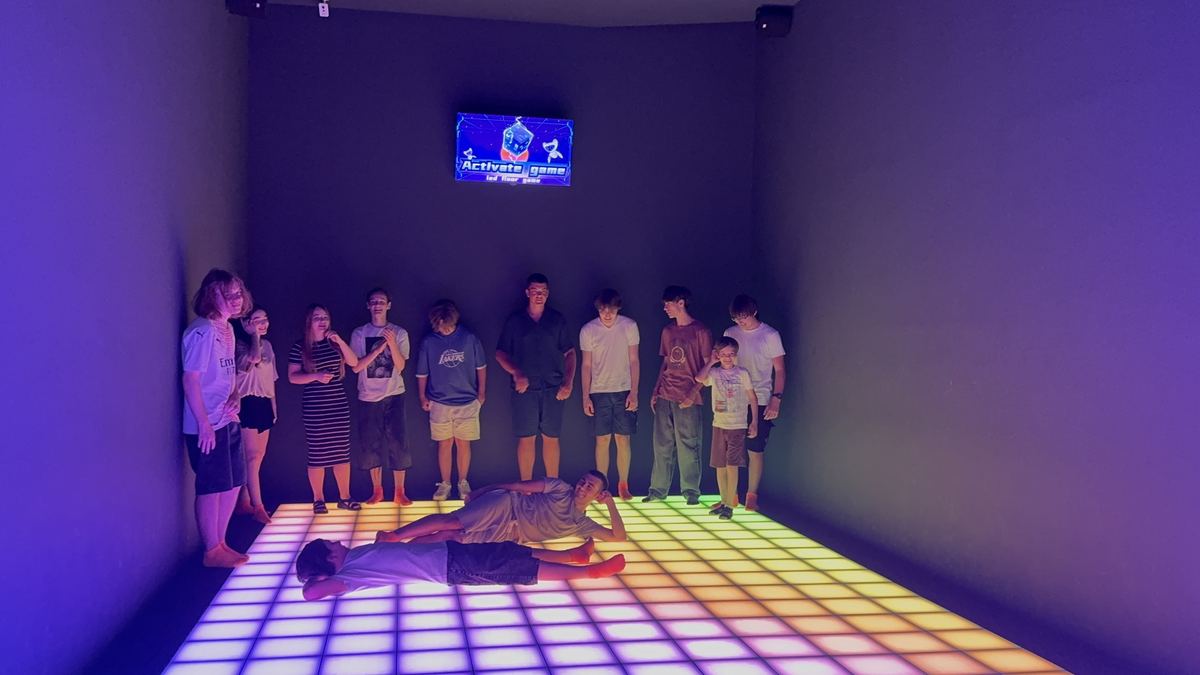 Grup de copii aliniați la linia de start a unui joc pe podeaua LED de la Hai Pixel din Chișinău