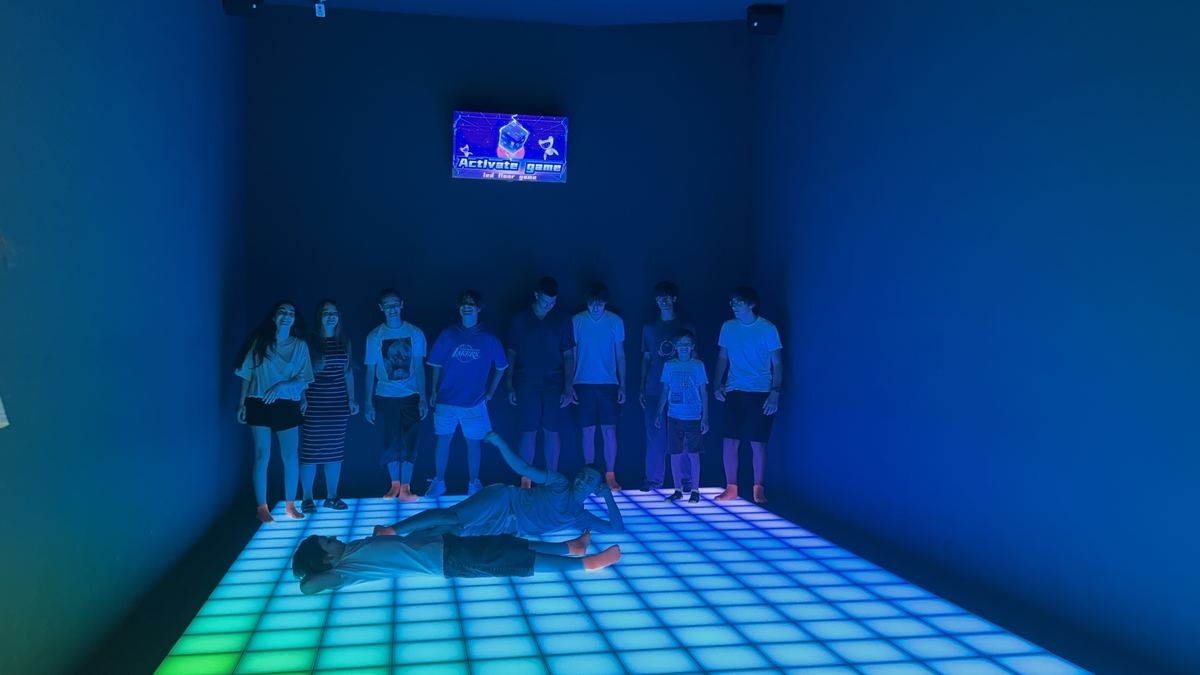 Grup de copii jucând pe podeaua LED verde și galbenă la Hai Pixel din Chișinău