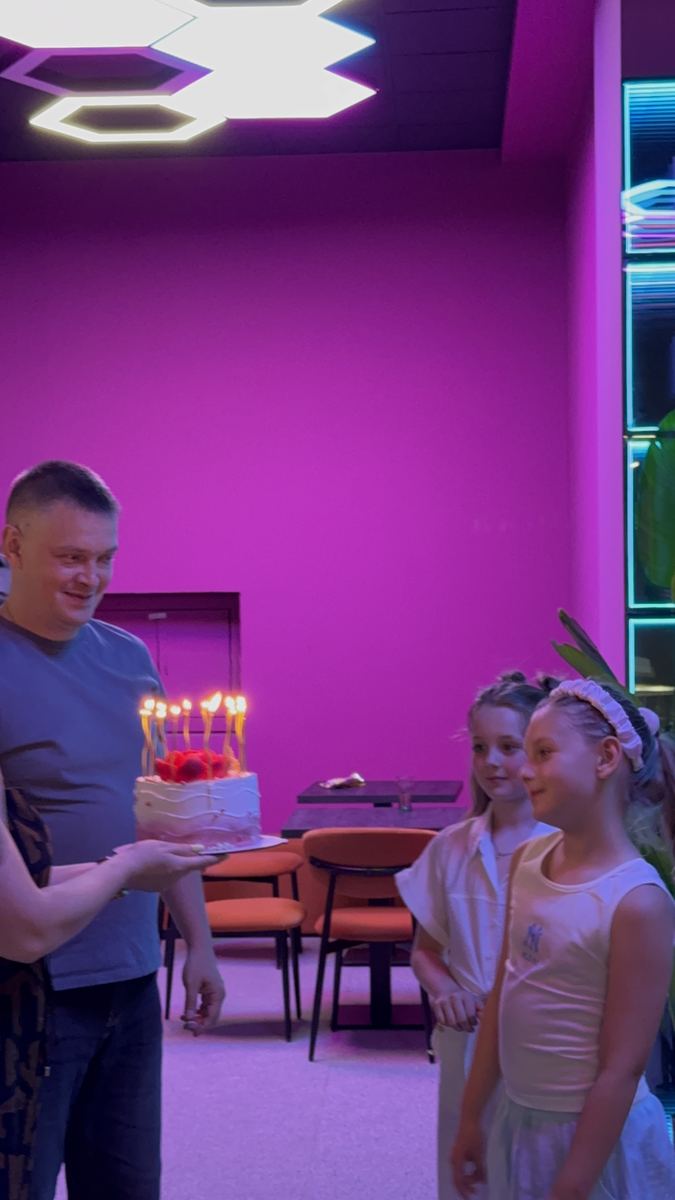 Momentul tortului cu lumânări la o petrecere de copii la Hai Pixel Chișinău, litere neon pe peretele roz