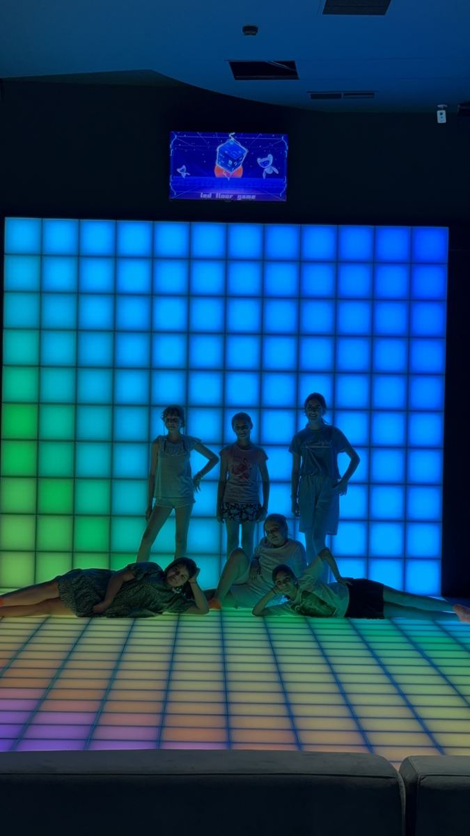 Grup în fața peretelui LED interactiv luminat în turcoaz, la Hai Pixel din Chișinău