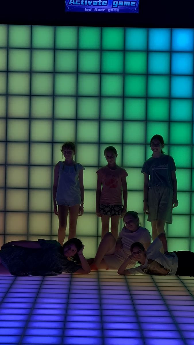 Perete LED interactiv luminat verde mentă, cu jucători în fața lui, la Hai Pixel Chișinău